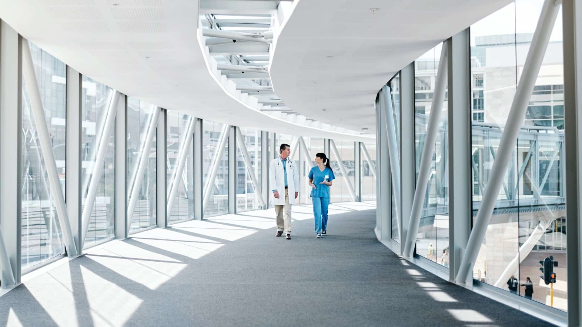 Doctor and nurse walking through a hospital skywalk