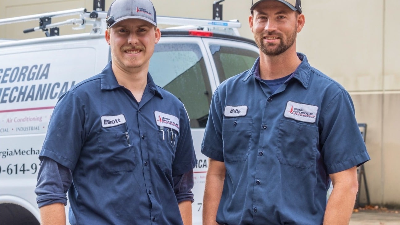 Two Georgia Mechanical technicians in front of a company service van