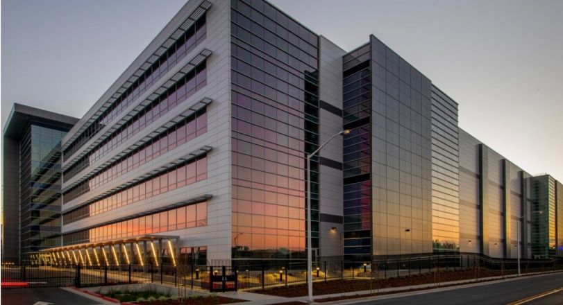 Modern commercial office building with a glass facade at sunset