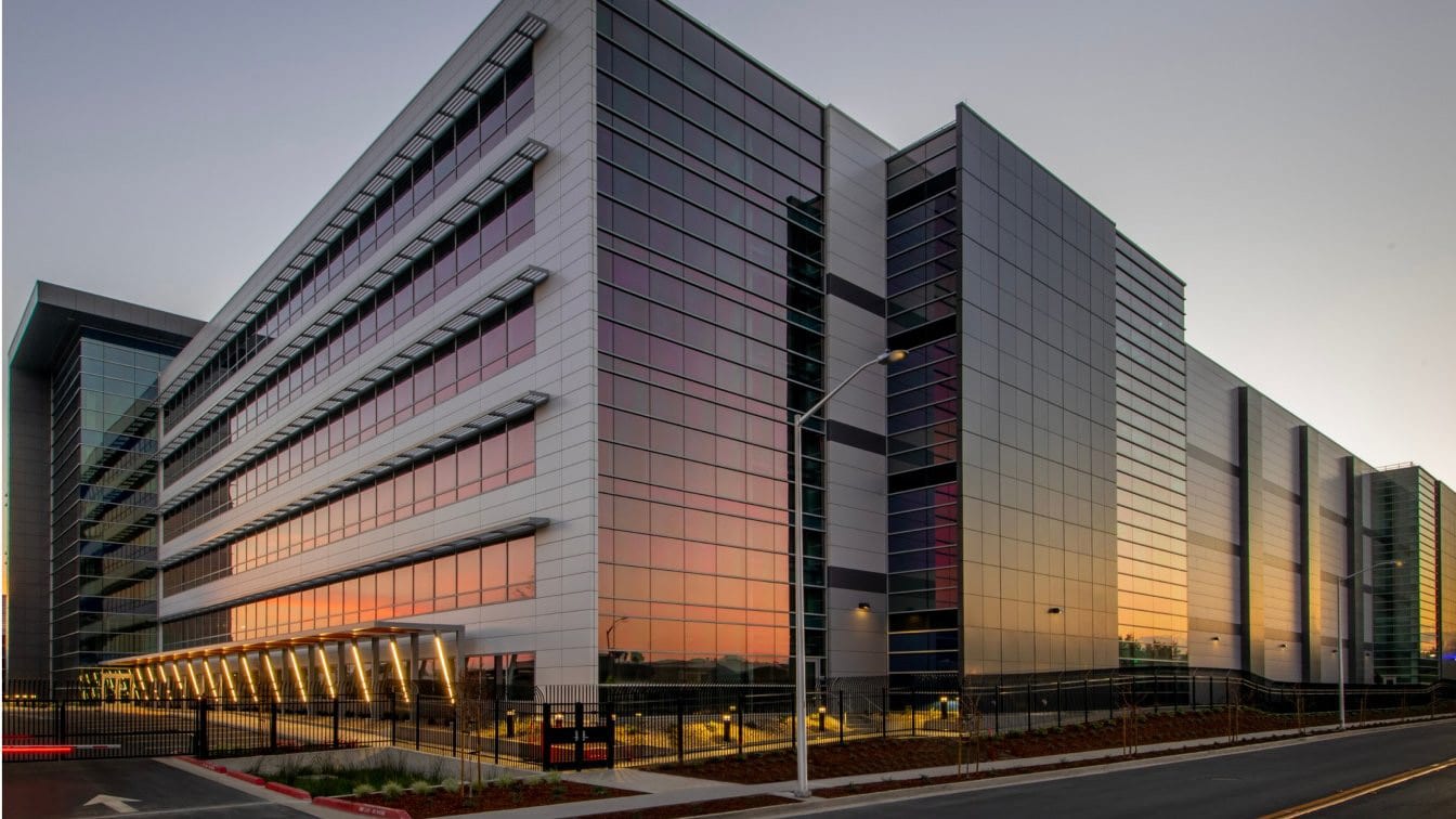 Modern commercial office building with a glass facade at sunset